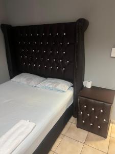 弗里尼欣Justy inn guest house的一张带黑色床头板和边桌的床