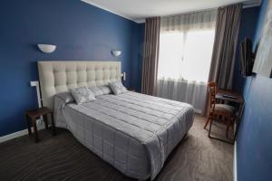 圣若里奥塞姆诺兹客栈的一间卧室设有一张大床和蓝色的墙壁