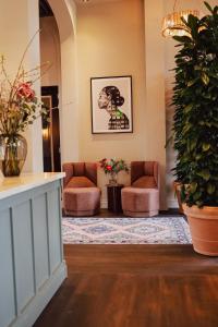 登博斯Hotel Ryder I Den Bosch - Vught的一间设有两把椅子和一株植物的等候室