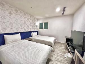 台北沃客商旅正义馆的酒店客房设有两张床和一台平面电视。
