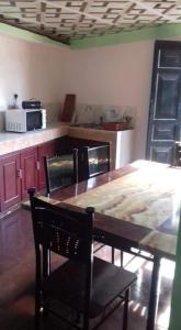 卡卢特勒Kuchi Villa的厨房配有带椅子的木桌和桌子。