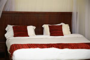 HoimaGLORY SUMMIT HOTEL HOIMA的一间卧室配有两张带红白色枕头的床