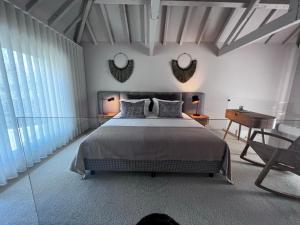 马尔科-德卡纳维泽斯Casas Bouça Maria - Aqua Village & Sports的一间卧室配有一张床、一张书桌和两面镜子