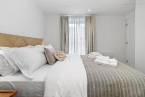伊斯特布恩Chic Urban Retreat: Modern Apartment in Eastbourne的白色的床、白色床单和枕头