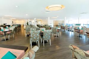 巴统Orbi City Sea View Beach Hotel的一间带桌椅的用餐室和一间自助餐厅