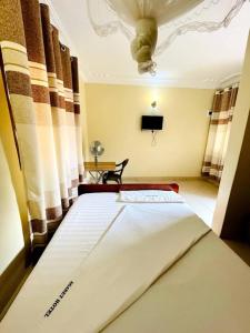 MbaleAgabet Hotel - Mbale的一间卧室设有一张带天花板的大床