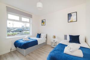 雷纳姆Heads-On-Beds Rainham Essex - 4Bedrooms with Garden的卧室设有两张床,带窗户