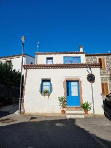 A casa di Pietro的街上有一扇蓝色门的白色房子