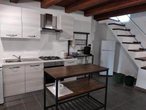 A casa di Pietro的一间带桌子的厨房和一间带楼梯的厨房