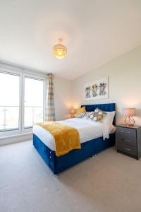 克劳利Modern 2 Bed Apartment in Crawley - Sleeps 5的一间卧室设有蓝色的床和2个窗户。