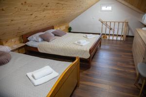 MačeMedeni raj的配有2张床的客房,铺有木地板,设有楼梯