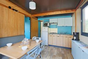艾克塞恩维克斯Camping La Pinède的厨房配有木桌和冰箱。