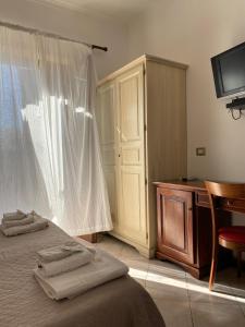 利帕里Mamamia Lipari的一间卧室配有一张床、一张书桌和一台电视