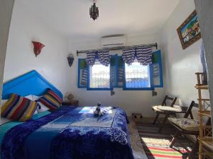 舍夫沙万Riad sakura的一间卧室配有一张带蓝色棉被的床和窗户。