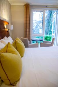 鲍内斯温德米尔The Belsfield Hotel的一间卧室配有一张带黄色枕头的大床