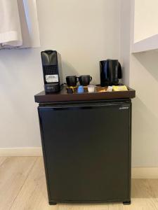阿斯蒂加拉加Pension Txingurri的黑色冰箱,上面有两个咖啡壶