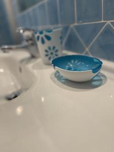 奇亚Casa Ada romantico appartamento的浴室水槽上有一个蓝色和白色的碗