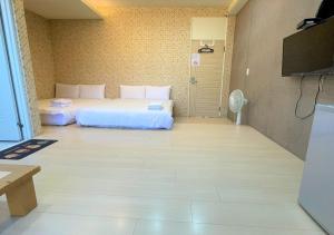 Hsia-shih-pi逢甲馨宿的一间卧室配有两张床和一台平面电视