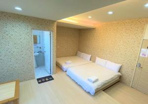 Hsia-shih-pi逢甲馨宿的一间带两张床的卧室和一间浴室
