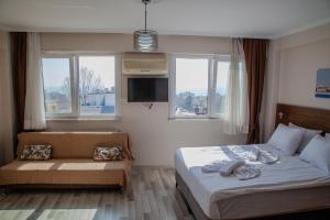 伊斯坦布尔City Hall Apart Hotel的一间卧室配有一张床、一张沙发和窗户。