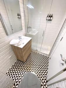 直布罗陀Delightful City Centre Studio Clarendon Apartment - Grand Central House的一间带水槽和淋浴的浴室