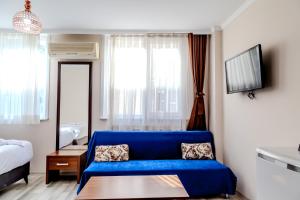 伊斯坦布尔City Hall Apart Hotel的客厅配有蓝色的沙发和床。