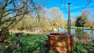 ToddingtonExclusive Coach House with Lakeside Hot Tub on Country Estate的湖旁草木桶