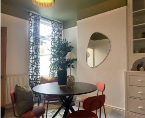 考文垂Coventry Lovely House, Sleeps 4, by Empower Homes的一间带桌椅和镜子的用餐室