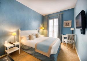 蒙彼利埃阿拉贡酒店的一间卧室设有一张大床和蓝色的墙壁