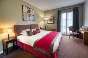 蒙彼利埃阿拉贡酒店的酒店客房设有一张大床和一张书桌。