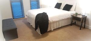 克劳利2 Bed Crawley Apt - Near Gatwick的一间卧室配有一张黑色长袍的床