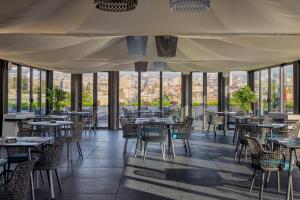 卡塔尼亚Palace Catania | UNA Esperienze的餐厅设有桌椅和窗户。