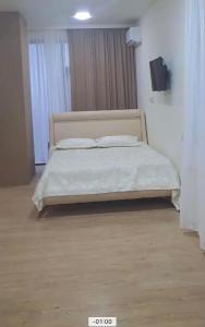 巴统Almare Batumi的卧室配有一张带白色床单和枕头的大床。