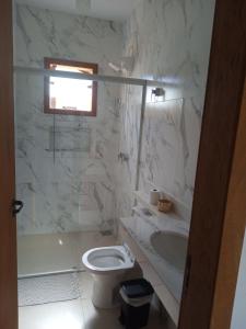 圣安娜杜里亚舒Pousada Quatro Estações的浴室配有卫生间、浴缸和水槽。