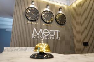 伊斯坦布尔Meet İstanbul Hotel Kadikoy的墙上有三个钟,字不意是伊斯坦布尔酒店