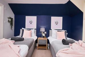巴斯The Moss x Monroe Suite - In Central Bath的蓝色墙壁客房的两张床