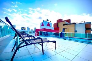 若昂佩索阿10ª Pirâmide Manaíra by Allmare Apartamentos的坐在建筑物屋顶上的长凳