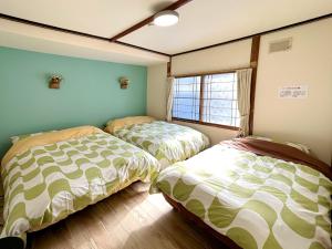 登别Mint / 11min walk to Noboribetsu st的带窗户的客房内的两张床