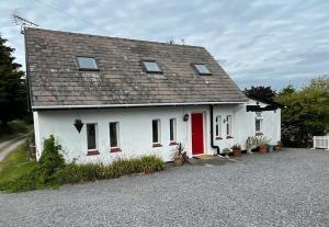 卡马森Barn Owl Cottage, The Welsh Reindeer Retreat, Ystradfach Farm , Llandyfaelog, Carmarthen , SA17 5NY的一间红色门的白色房子