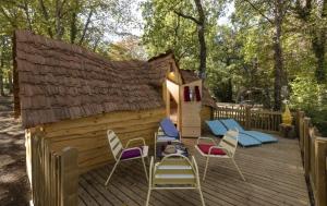 AndryesCamping USHUAÏA Villages Au Bois Joli的一个带椅子的木甲板和游戏房