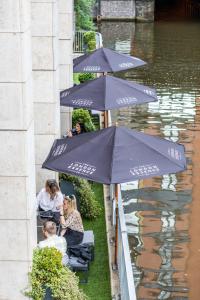 曼彻斯特曼彻斯特城市中心假日酒店的一群人坐在水边的伞下