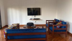 ChavanineHouse 16 - Kweli and Kael的客厅配有蓝色的沙发和两把椅子