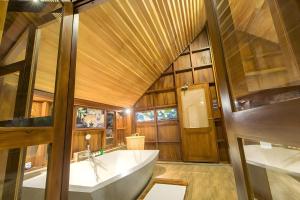 维勒珀图Glamping Wilpattu by Thamaravila的一间带大浴缸和木制天花板的浴室