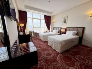 麦加Al Rayyan Towers 1的酒店客房设有两张床和大窗户。