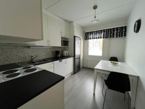 拉赫蒂Tilava huoneisto的厨房配有白色橱柜和黑色台面