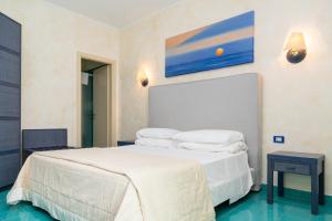 马蒂纳塔AH Premium Baia dei Faraglioni的一间卧室配有带白色床单和枕头的床。