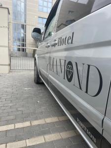基希讷乌Diamond Hotel的停在大楼旁边的人行道上的银车