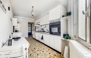 Issy-lʼÉvêque3 Bedroom Pet Friendly Apartment In Issy-lvque的厨房配有白色橱柜和瓷砖地板。