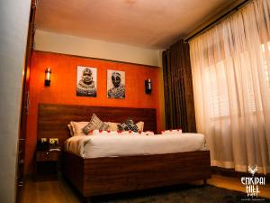 NarokEnkipai Hill Hotel的一间卧室配有一张橙色墙壁的床