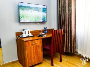NarokEnkipai Hill Hotel的一张带椅子的木桌和墙上的电视